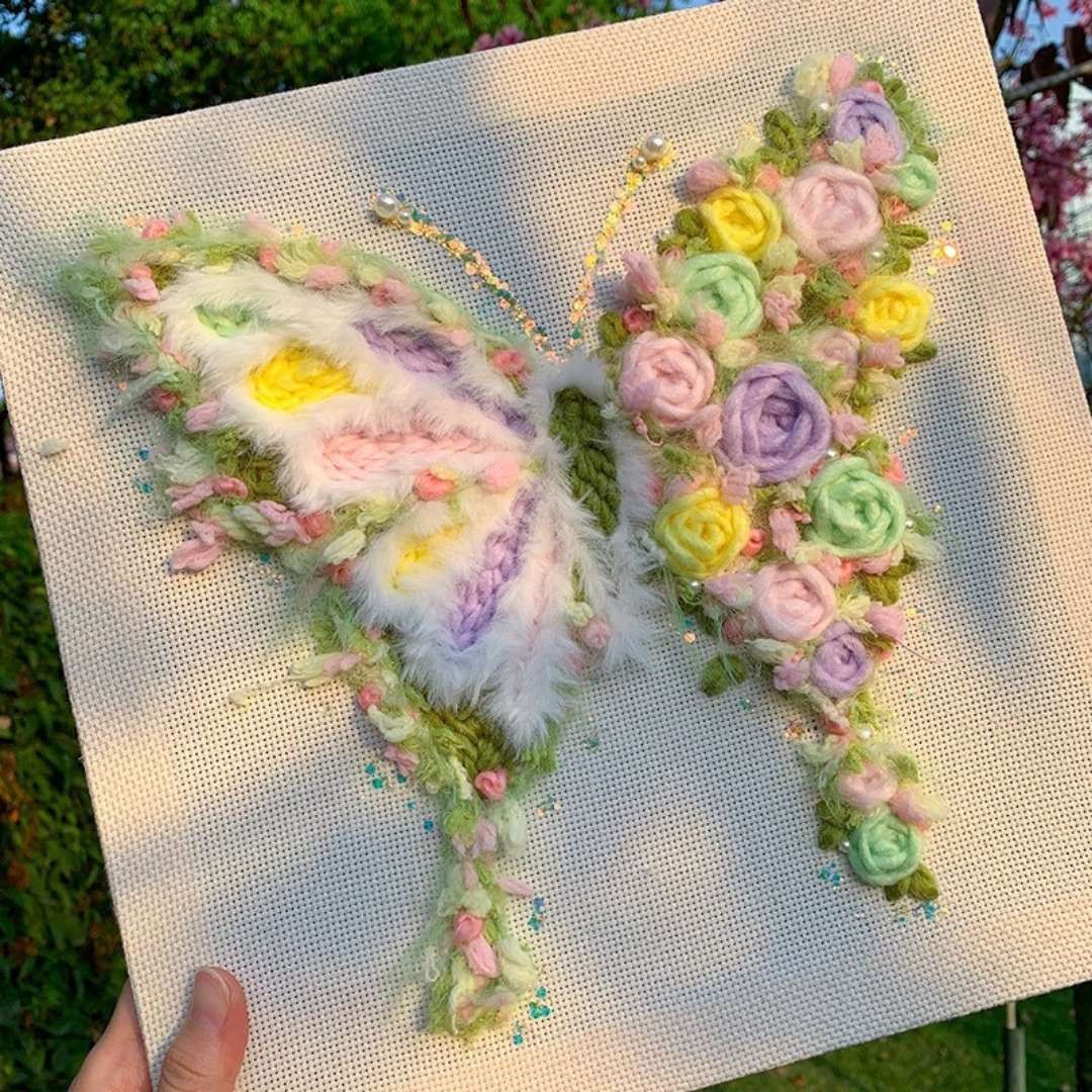 Puddingcase punch needle kit featuring a butterfly with vibrant pastel floral details, photographed outdoors, perfect for DIY embroidery and home decor.